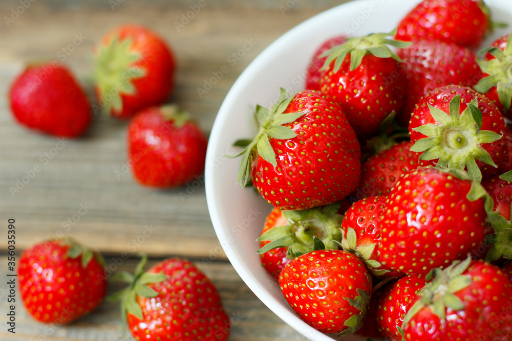 Fresh strawberries in a bowl on wooden background. Fresh strawberries in a bowl on wooden background.