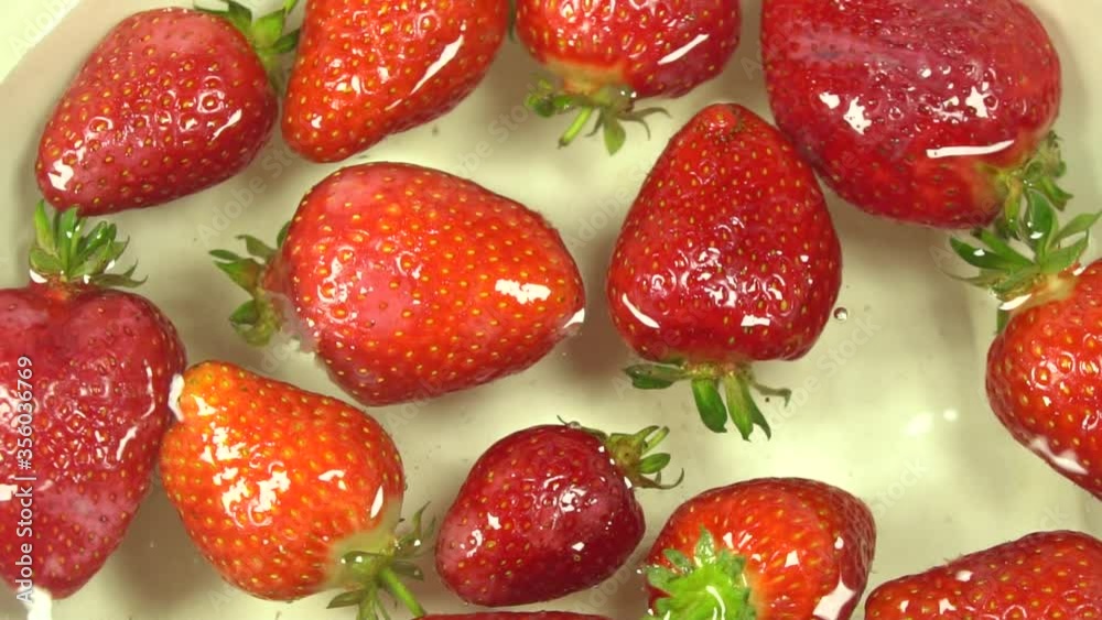 Slow motion rotation of juicy strawberries. Top view, Rotation 360 degrees, Extreme close up Slow motion rotation of juicy strawberries. Top view, Rotation 360 degrees, Extreme close up