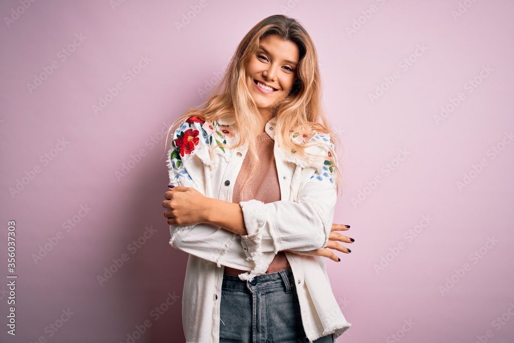 Young beautiful blonde woman wearing casual jacket standing over isolated pink background happy face smiling with crossed arms looking at the camera. Positive person. Young beautiful blonde woman wearing casual jacket standing over isolated pink background happy face smiling with crossed arms looking at the camera. Positive person.