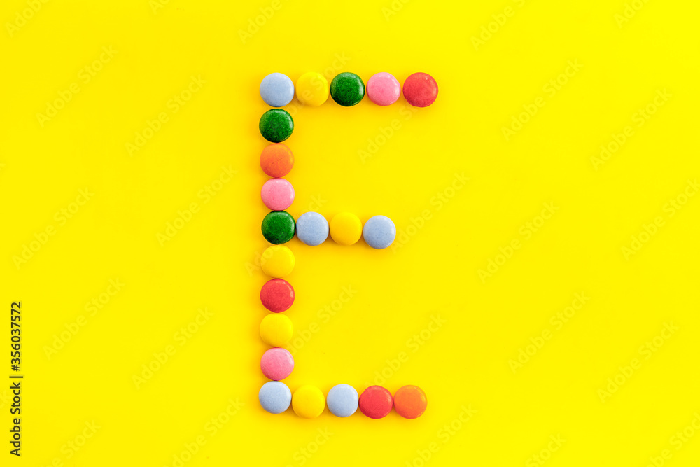 Letter E - alphabet made with sweets on yellow from above Letter E - alphabet made with sweets on yellow from above