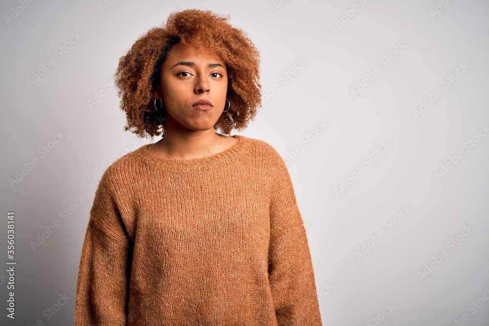 Young beautiful African American afro woman with curly hair wearing casual sweater Relaxed with serious expression on face. Simple and natural looking at the camera. Young beautiful African American afro woman with curly hair wearing casual sweater Relaxed with serious expression on face. Simple and natural looking at the camera.