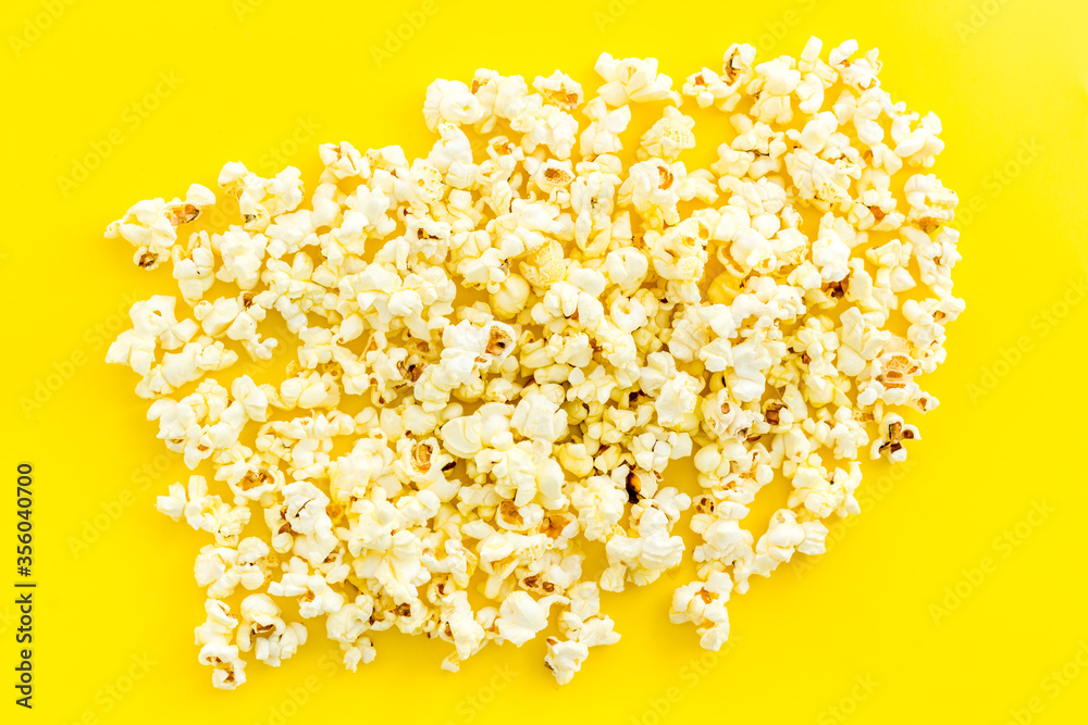 Popcorn scattered on yellow background top view Popcorn scattered on yellow background top view