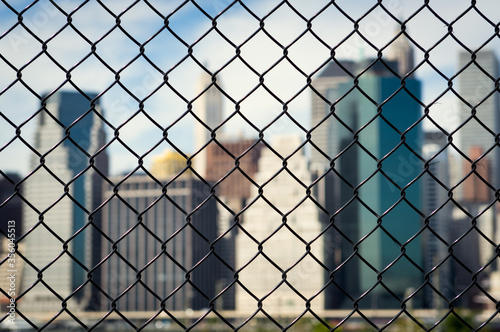New York city behind steel mesh wire fence. Concept