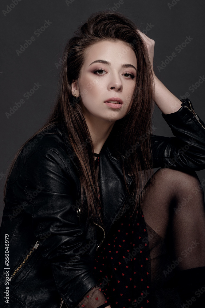 fashion model woman in a black jacket on a gray background fashion model woman in a black jacket on a gray background