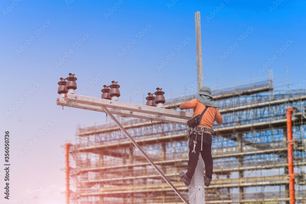 Naklejka premium Worker on the height wear safety harness, Electric lineman repairman worker at climbing work on electric post power pole in construction site on structure steel background.