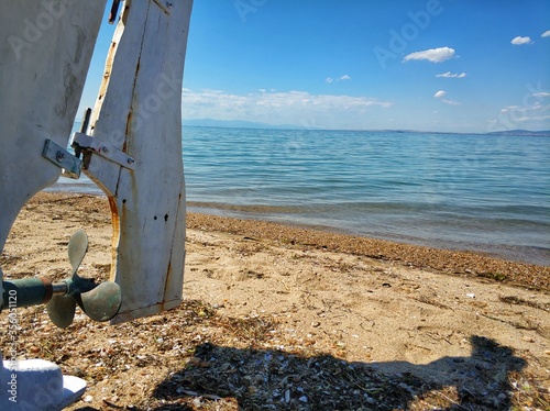 
A beach with blue water, fishing boats in the foreground in the area of Thessaloniki in Greece