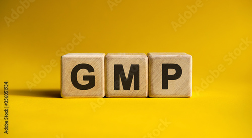 GMP text on a yellow background on wooden cubes photo