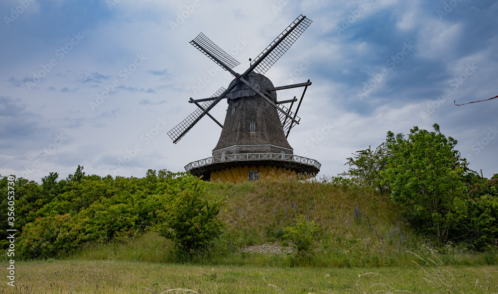 MIll on the hilltop with blue sky and clouds