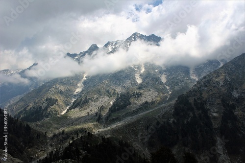 View of the High altitude Himalayan rocky mountains with clouds surrounding them like a ring.