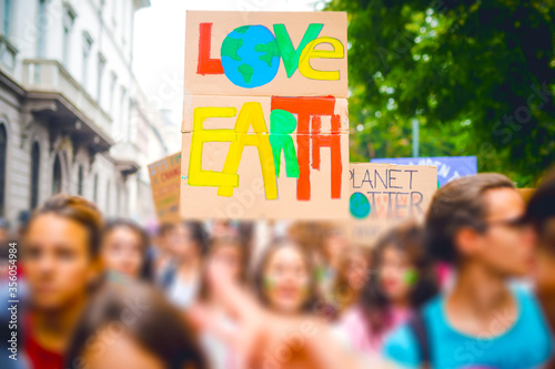 Tilt Shift of people holding picket signs climing for climate change in strike protest  - Activist manifestating claiming for changing in climate politics photo