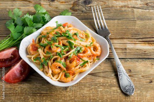 spaghetti with prawns in tomato sauce with herbs.