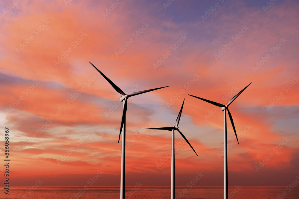 Wind turbines as alternative renewable energy on a background sunset sky.