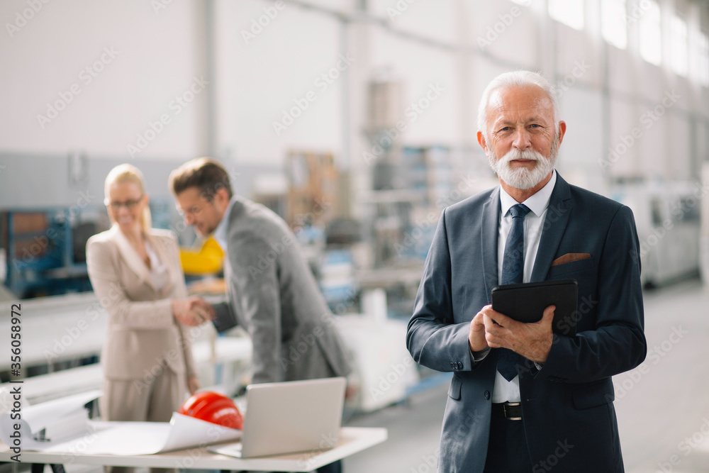 Portrait of handsome businessman. Man using tablet in factory. Portrait of handsome businessman. Man using tablet in factory.
