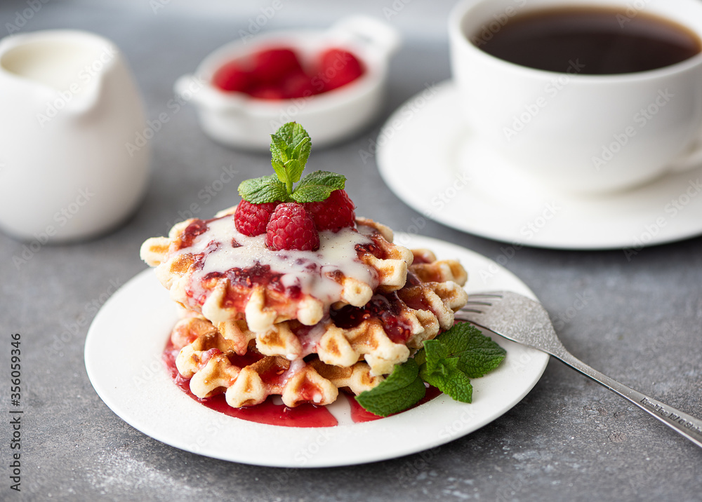 round waffles with sauce, raspberries and mint leaves round waffles with sauce, raspberries and mint leaves
