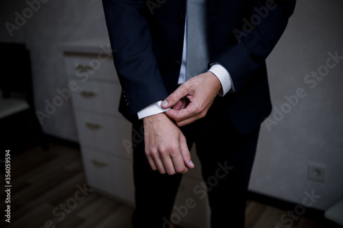 man puts on a suit in the room