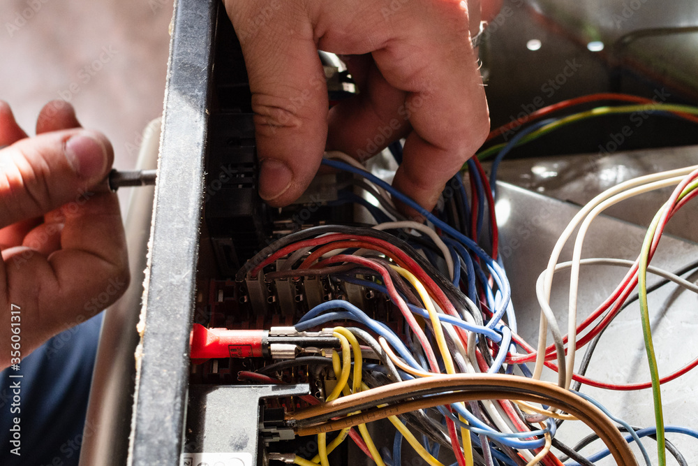 electrician disassembles electric oven during repair in home kitchen electrician disassembles electric oven during repair in home kitchen