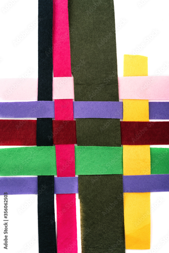 Threaded multi-colored strips of felt fabric horizontally on a white background.