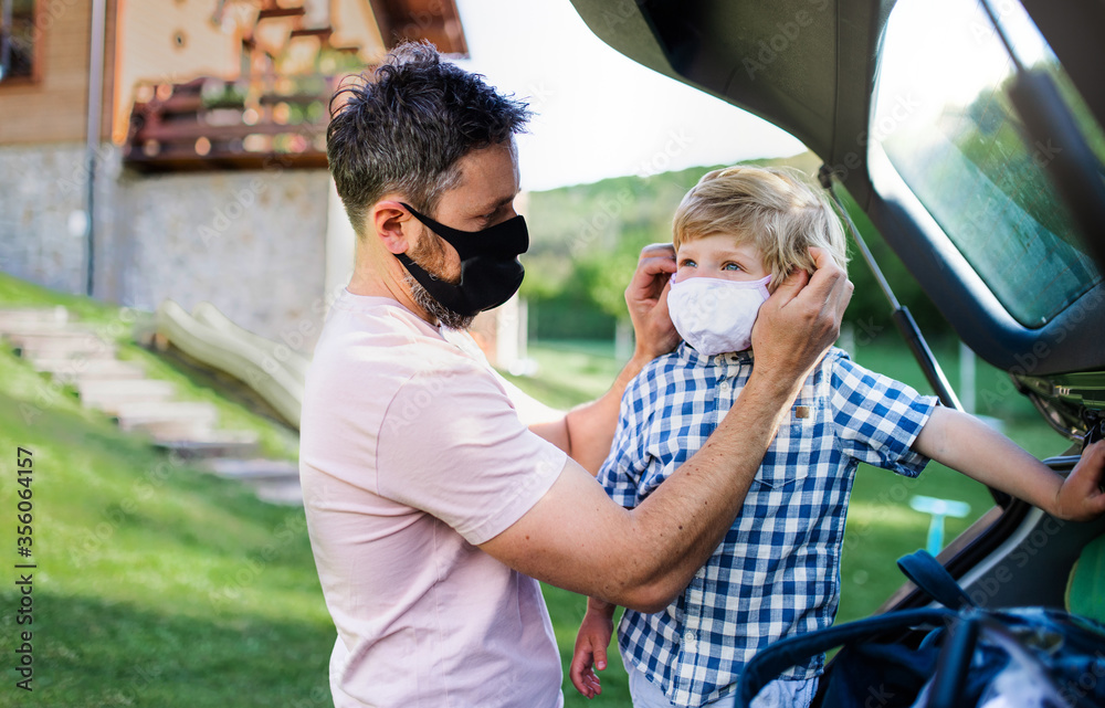 Father with small son going on trip by car, wearing face masks. Father with small son going on trip by car, wearing face masks.