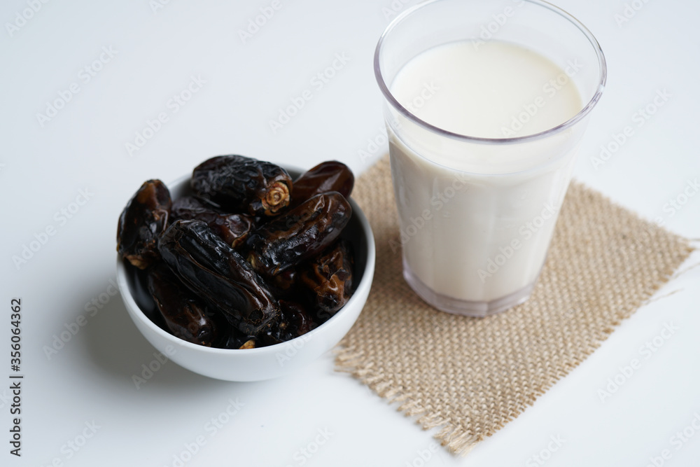 Dates milk and dates in the bowl on grey background.
Dates milk and dates in the bowl on grey background.