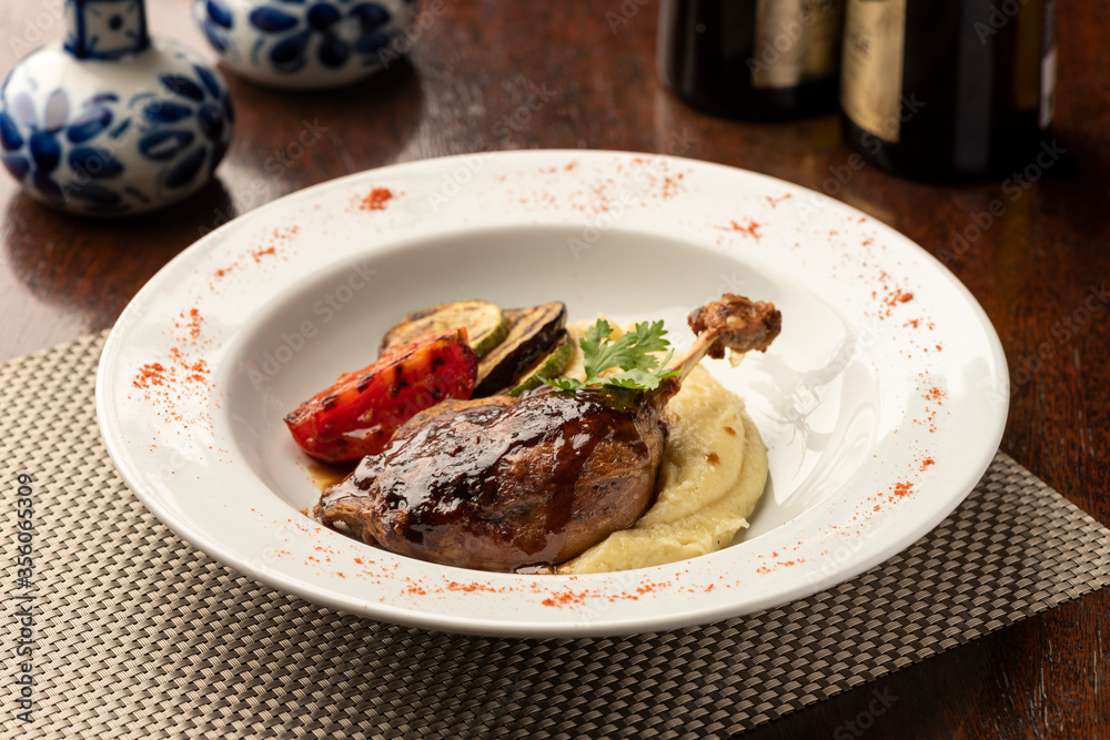 duck leg plate food with mashed potatoes and vegetables with blurred background duck leg plate food with mashed potatoes and vegetables with blurred background