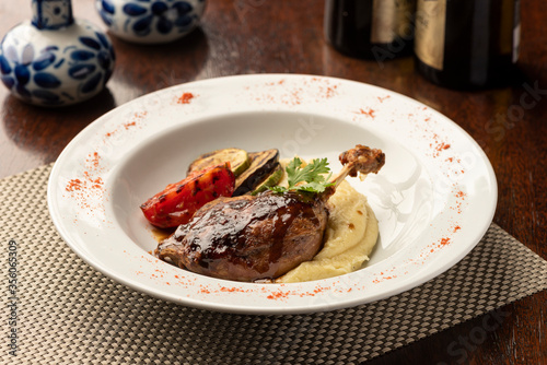 duck leg plate food with mashed potatoes and vegetables with blurred background