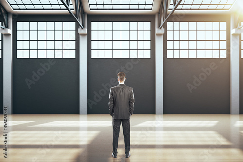 Businessman standing in contemporary hangar interior
