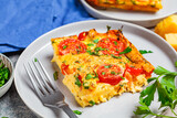 Portion of traditional egg frittata (omelet) with tomatoes and cheese in gray plate.