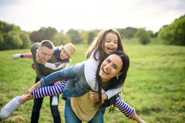 Happy family with two small daughters having fun outdoors in spring nature.