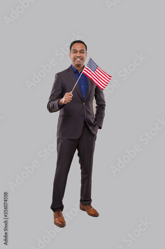 Businessman Waving American Flag. Indian Businessman Standing Full Length with USA Flag in Hands