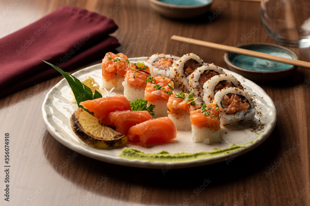 Japanese sushi sashimi salmon set on plate with napkin chopsticks on background
