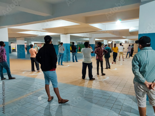 People Practice Social Distancing Outside Grocery Store. Customers Standing Inside Circle At two meters Distance To Prevent The Spread Of COVID-19 photo