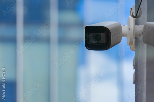 CCTV security camera on modern building wall in city
