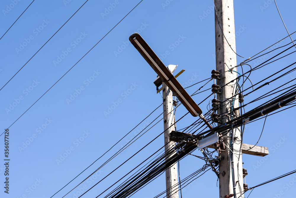 Fototapeta premium Old Street light on concrete pole with tangle of electrical cables.