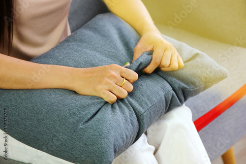 Asian woman patient pinch to gray pillow between the psychologist talk to her illness at clinic.