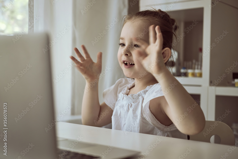 Cute little girl using laptop at home. Education, online study, home studying The girl at home communicates with friends on the Internet. Kids distance learning. High quality photo Cute little girl using laptop at home. Education, online study, home studying The girl at home communicates with friends on the Internet. Kids distance learning. High quality photo