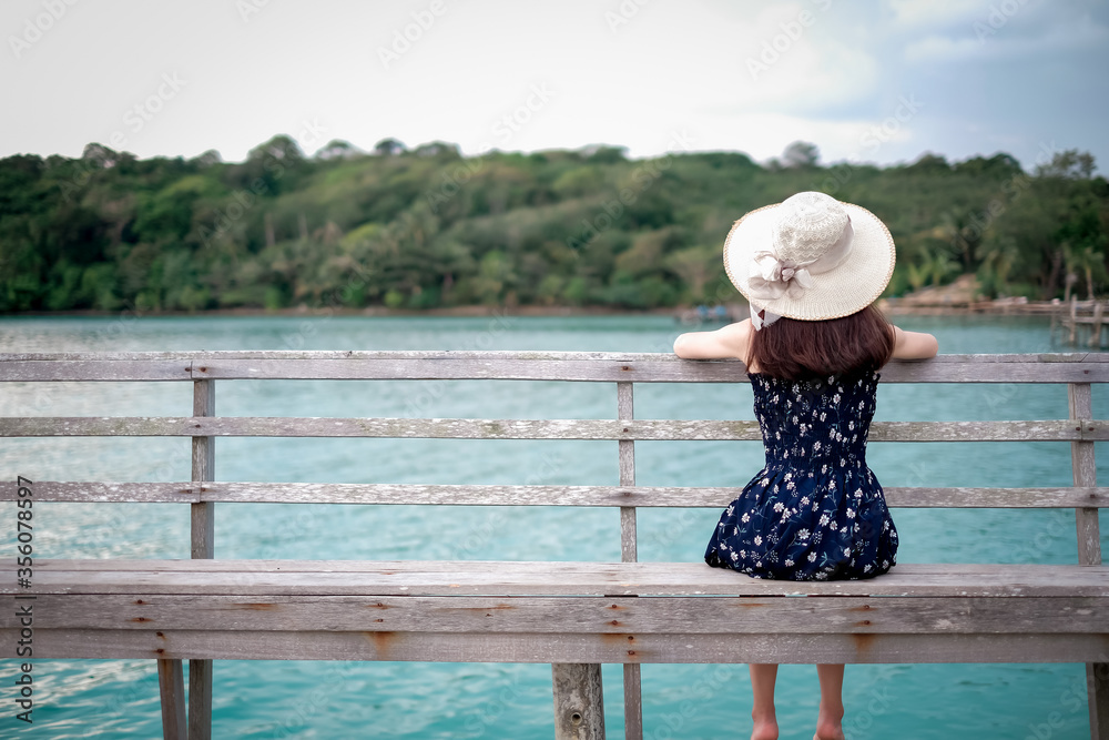 Asian woman tourists watching the sea view and admiring And the clear skies with beautiful clouds. Suitable for tourism, recreation and relax. at  Koh Kood Thailand.