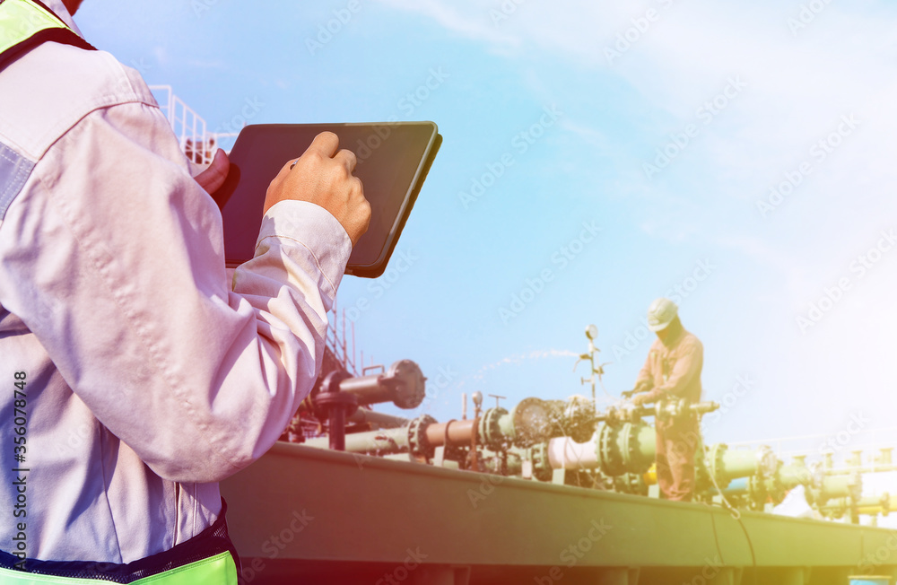Workers hand holding tablet computer, Oil And Gas Industry. Work on the ...