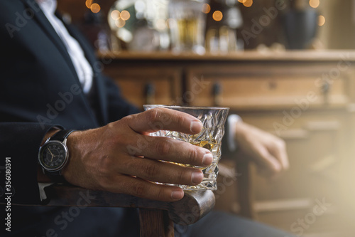Male hand with a glass of expensive whiskey