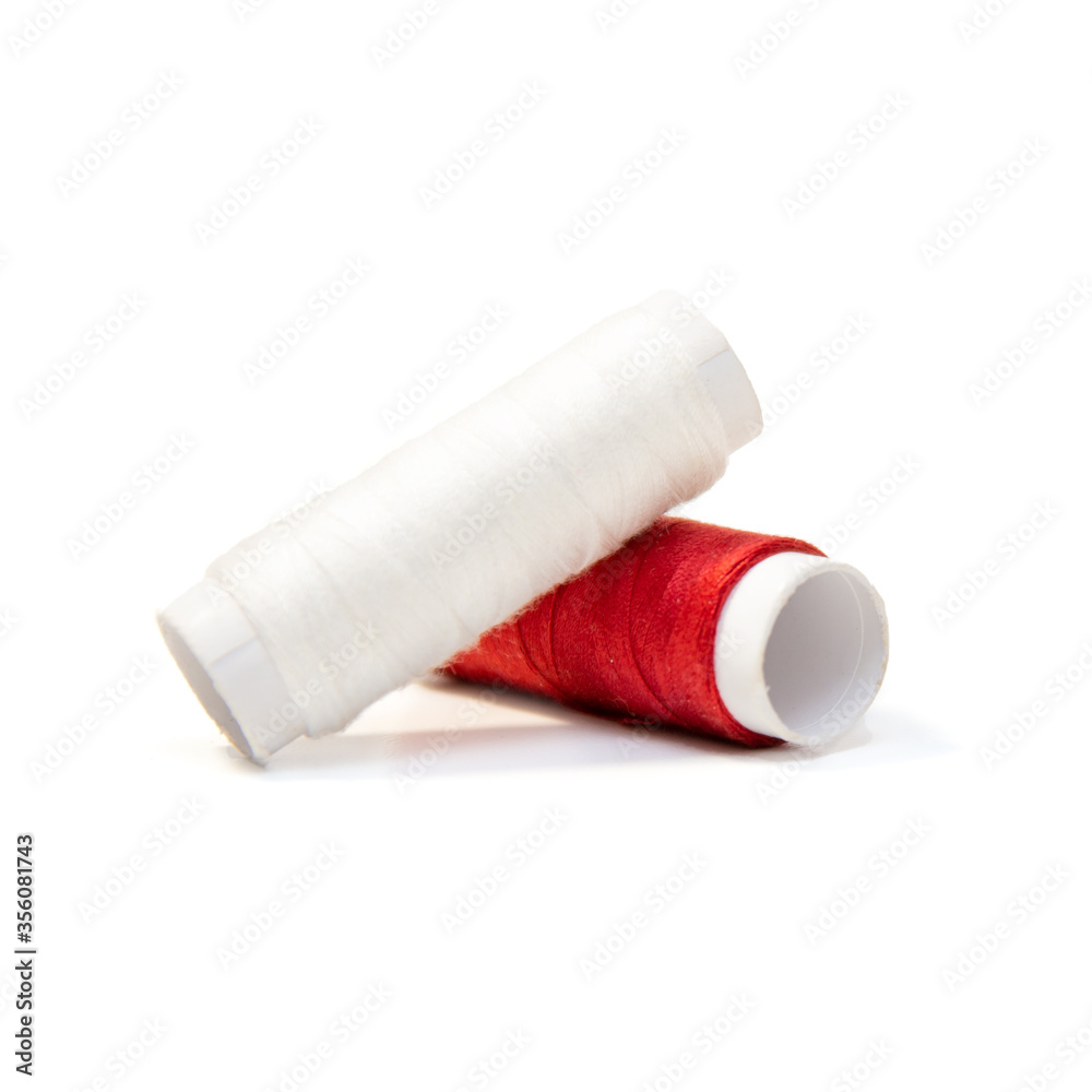 Two spools of thread isolated. Red and white threads. Two spools of thread isolated. Red and white threads.