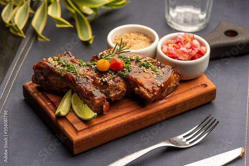 Ribs on barbecue on a wooden board with a blurred background