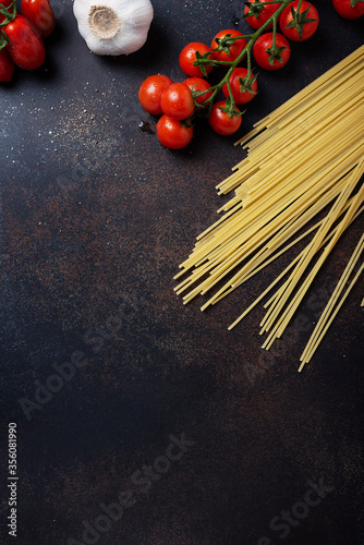 spaghetti, tomato and garlic on the black table