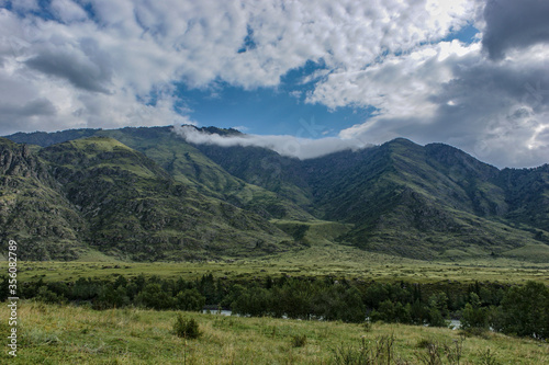 Altai mountains near the Katun river on a background of clouds. Green mountains and valley. Altai. Siberia.