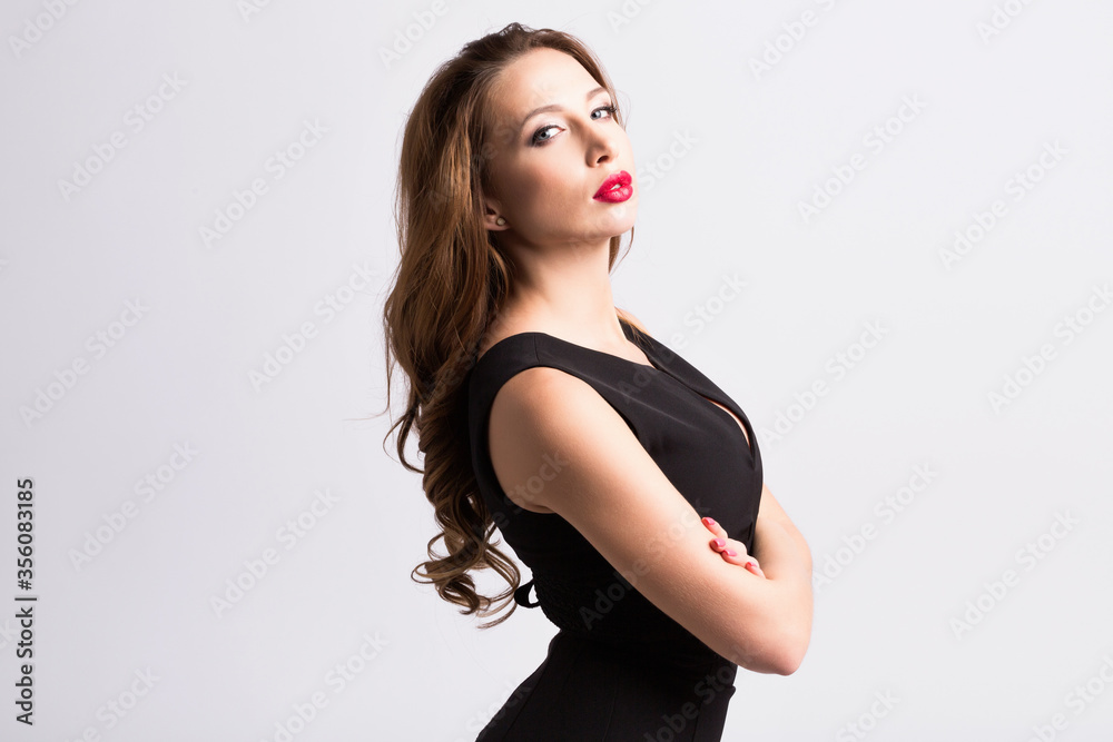 Fototapeta premium Young beautiful woman wearing black dress posing over grey