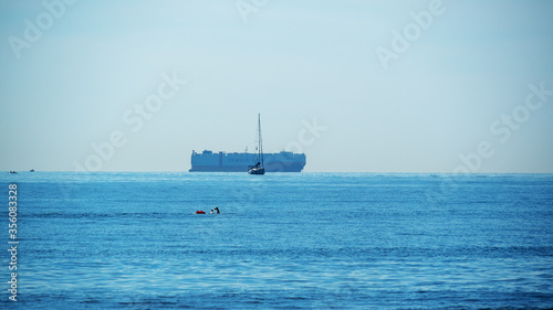 a container ship boat swimmer and  blue sea