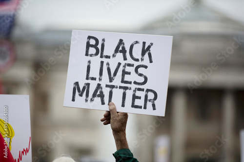 A person holding a black lives matter banner at a protest photo