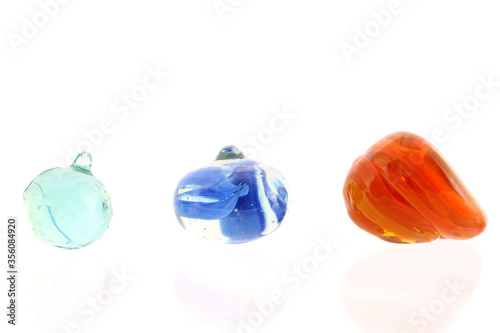 Photo showing rejected toy marbles. The first has a spru from casting, as does the second which is also squashed and the third orange marble has collapsed whilst molten.