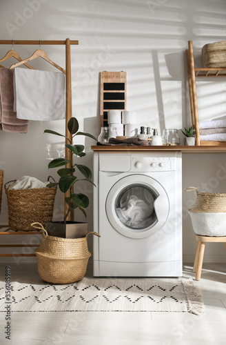 Stylish bathroom interior with modern washing machine