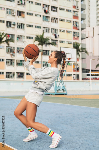 Young stylish woman  is posing on the Choi Hung Estate Basketball Court © blackday