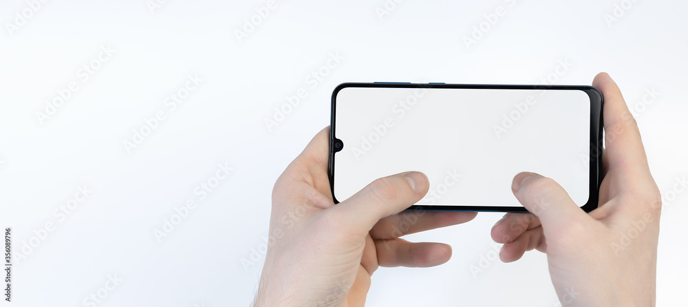 Obraz premium Male hands holding smartphone with blank screen horizontally on white background