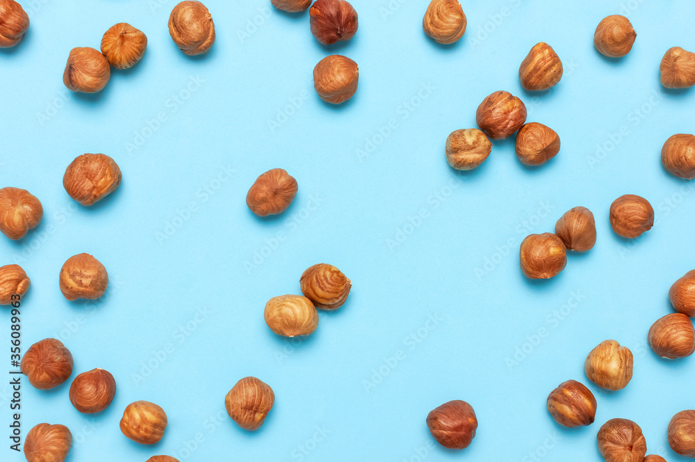Creative food layout. Hazelnuts on blue background top view copy space. Concept of food, healthy nutrition, nut, healthy fats. Hazelnut Flat lay. Walnut pattern. Organic healthy vegan snack Creative food layout. Hazelnuts on blue background top view copy space. Concept of food, healthy nutrition, nut, healthy fats. Hazelnut Flat lay. Walnut pattern. Organic healthy vegan snack